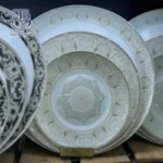 بشقاب سفید با طرح های کرم و سفید روی تخته چوبی