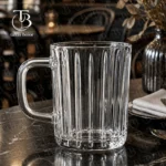 لیوان دسته دار شفاف از جنس بلور مدل KTZB136 برند بلینک مکس روی یک میز