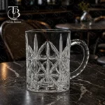 لیوان دسته دار از جنس بلور روی میز مشکی