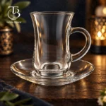 فنجان نعلبکی شیشه ای از جنس بلور روی یک میز چوبی