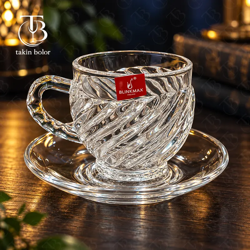 فنجان نعلبکی شیشه ای از جنس بلور روی یک میز چوبی