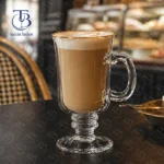 لیوان پایه دار کافی لب طلایی از جنس بلور روی یک میز