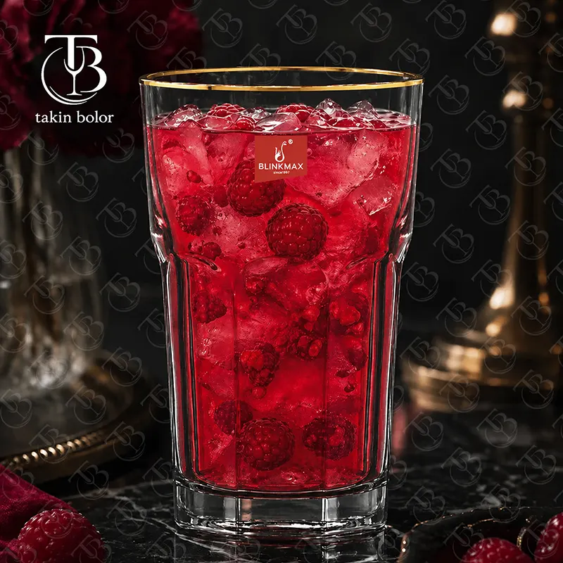 لیوان شربت خوری شیشه ای لب طلایی از جنس بلور روی یک میز