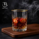نیم لیوان شیشه ای از جنس بلور لب طلایی روی یک میز