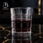 نیم لیوان شیشه ای از جنس بلور روی یک میز مشکی