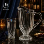پارچ و لیوان شیشه ای از جنس بلور روی یک میز مشکی