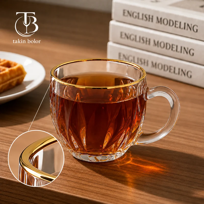 فنجان شیشه ای لب طلا از جنس بلور روی یک میز