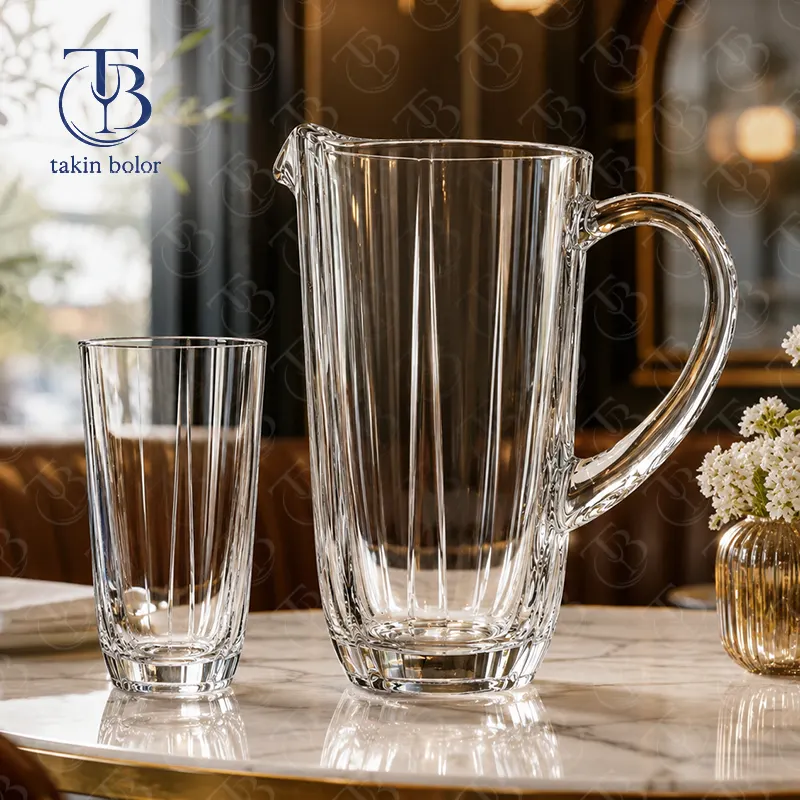 پارچ و لیوان شیشه ای از جنس بلور روی یک میز