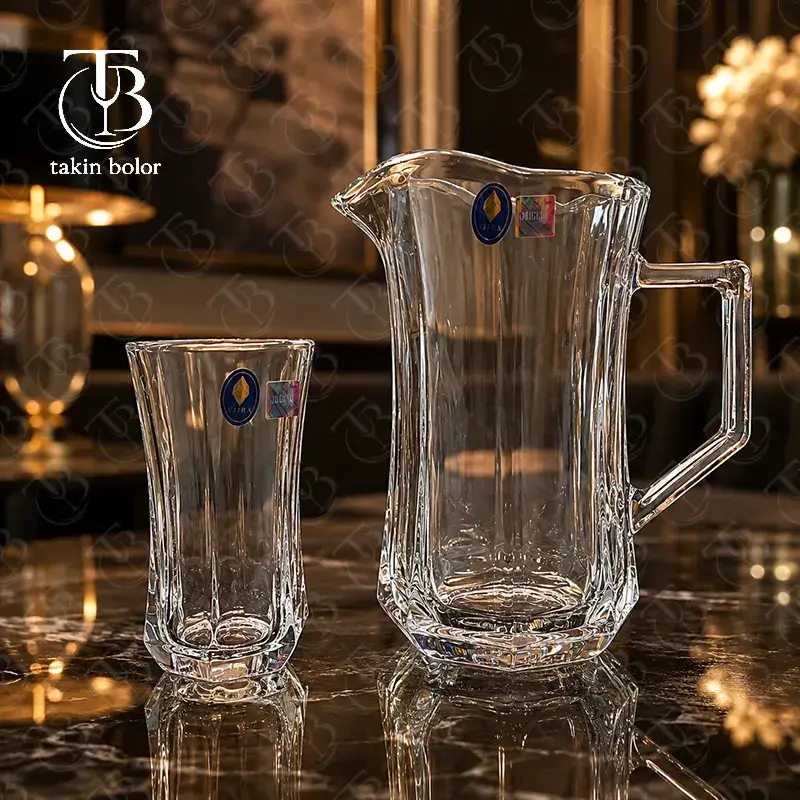 پارچ و لیوان شیشه ای از جنس بلور روی یک میز