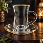فنجان نعلبکی شیشه ای از جنس بلور روی یک میز چوبی