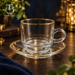 فنجان نعلبکی شیشه ای لب طلا از جنس بلور روی میز چوبی