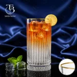 لیوان شربت خوری شیشه ای لب طلا از جنس بلور روی یک میز