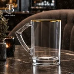 لیوان شیشه ای لب طلا از جنس بلور روی یک میز مشکی