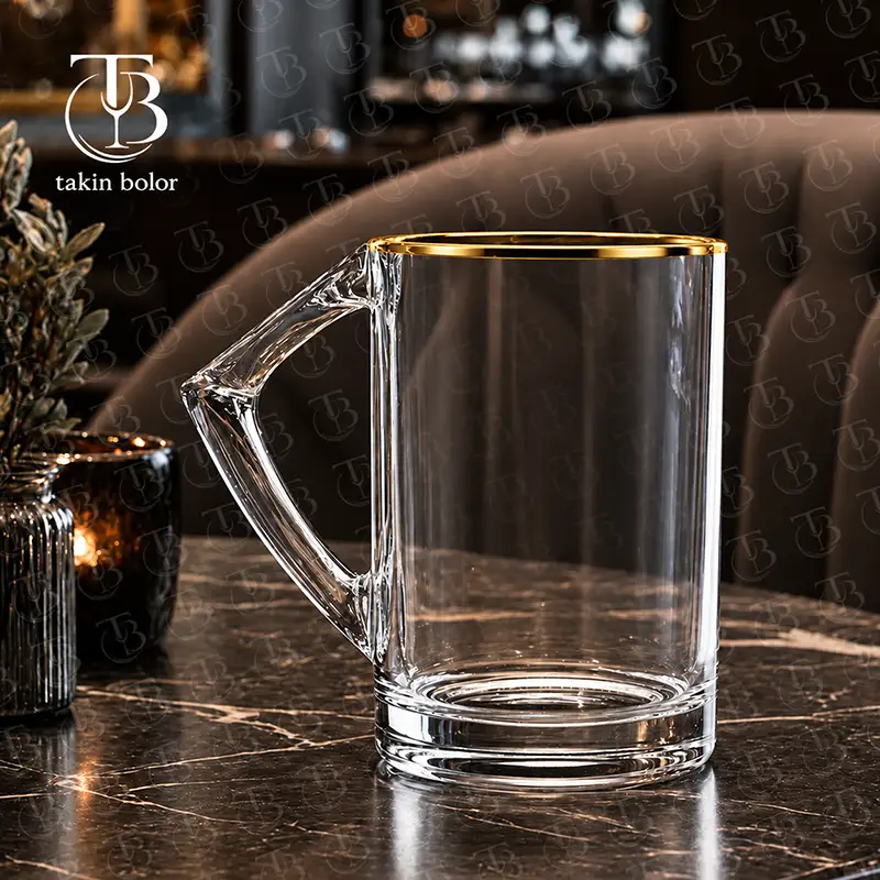 لیوان شیشه ای لب طلا از جنس بلور روی یک میز مشکی