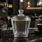 قندان شیشه ای لب طلا از جنس بلور روی یک میز مشکی